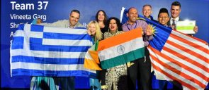 Mr Komianos, holding the greek flag along with his teammates and the other flags, smiling