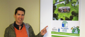Mr Sarantidis points his finger on the green flag award banner