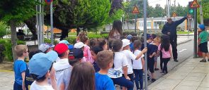 Τα Νήπια των Εκπαιδευτηρίων, με αφορμή τη θεματική ενότητα «Μαθαίνω να κυκλοφορώ με ασφάλεια», επισκέφθηκαν το Πάρκο Κυκλοφοριακής Αγωγής Καλαμαριάς στέκονται σε μια γραμμή όπου ένας κύριος τους δείχνει ένα φανάρι